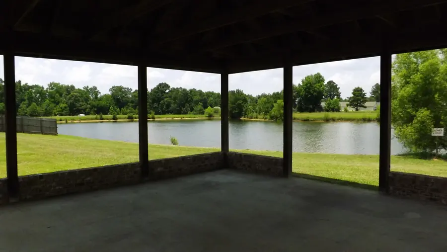 View out of the open-sided Waterbury pavilion across a mowed lawn to the neighborhood's private lake
